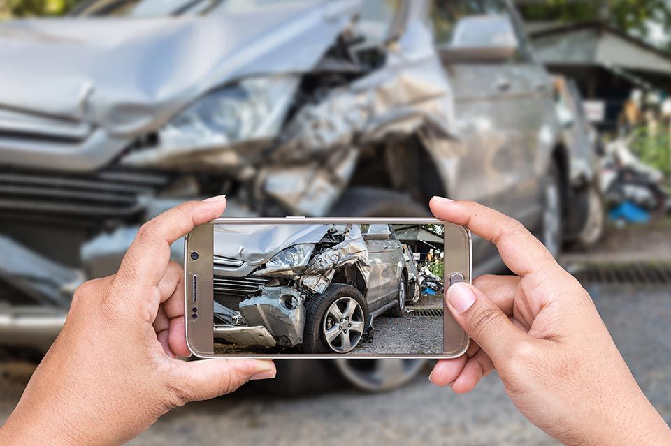 Person taking picture with phone of Car Crash