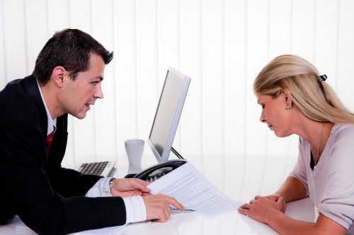 Male attorney explaining legal paperwork to woman client.
